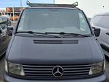 La camionnette est garée sur le parking, à côté d'autres voitures.