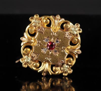 gros plan d'une bague en or avec une pierre rouge au centre