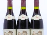 trois bouteilles de vin rouge posées l'une à côté de l'autre sur une surface blanche