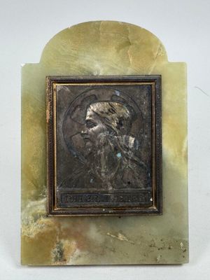 une image d'un homme barbu sur une plaque de marbre