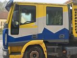 a yellow and blue tow truck parked on the side of the road