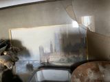 une photo d'un tableau accroché au mur au-dessus d'un lavabo