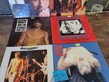 the rolling stones album covers are on a wooden table