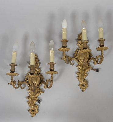 pair of antique brass wall sconces with white candles