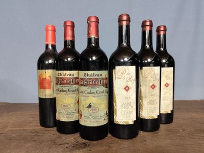 six bottles of red wine are lined up on a wooden table