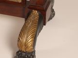 a small wooden table with a mirror and a gold leaf decoration