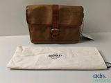 Le sac marron est posé à côté d'un sac blanc sur une table.