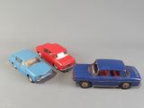 three toy cars are sitting side by side on a white surface