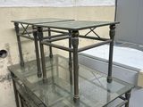 trois tables avec des plateaux en verre et un réfrigérateur à l'arrière-plan
