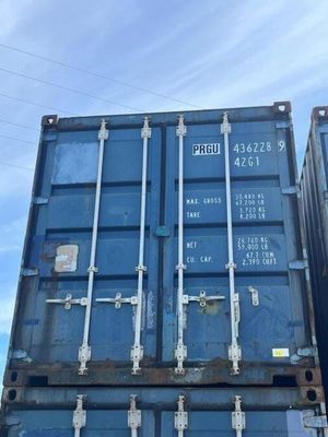 two blue shipping containers stacked on top of each other in a parking lot