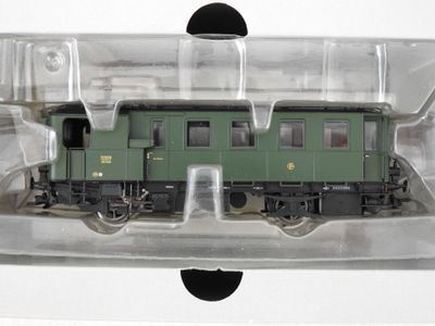 un train vert dans une boîte transparente posée sur une surface blanche