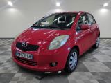 une photo d'une Toyota Yaris rouge garée sur un sol à damier