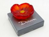 a red flower sitting on top of a black box