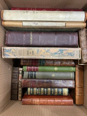 many books in a box that are stacked on top of each other