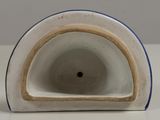 a white and blue vase with a hole in it