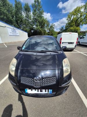 a black car parked in a parking lot next to a van