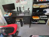 a black desk with a red chair in front of it