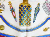 an image of a picture of a table cloth with a picture of a perfume bottle on it