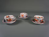 trois tasses et soucoupes ornées de motifs orange et bleus