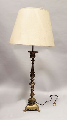 une lampe de table ancienne en laiton avec un abat-jour blanc, sur fond blanc
