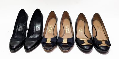 quatre paires de chaussures noires ornées de nœuds sont alignées sur une surface blanche