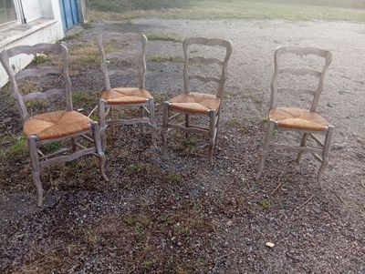four chairs sitting in a circle in front of a house