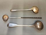 three spoons and a spoon rest on a table next to each other