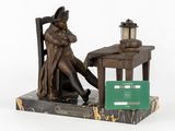 a statue of a man sitting at a desk with a green card