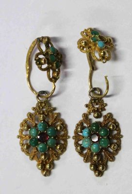 une paire de boucles d'oreilles ornées de pierres vertes et rouges
