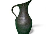 a green vase that is sitting on a white surface