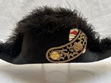 un chapeau noir orné d'une bordure dorée et un chapeau noir orné d'une bordure dorée