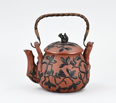 théière en forme de théière, décorée de fleurs et de feuilles