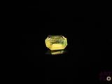 a yellow diamond on a black surface with a black background