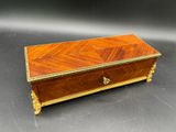 une petite boîte en bois ornée d'un motif doré sur le couvercle