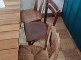 four wooden chairs sitting at a table in a restaurant