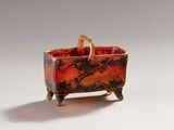 a red and black bowl with a handle on it