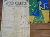une affiche accrochée au mur, à côté d'une affiche posée par terre