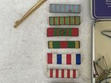 a small tin with pins and a pair of scissors in it