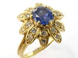 Gros plan sur une bague en or ornée d'un saphir bleu et de diamants