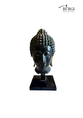 the head of a statue of a buddha on a black base