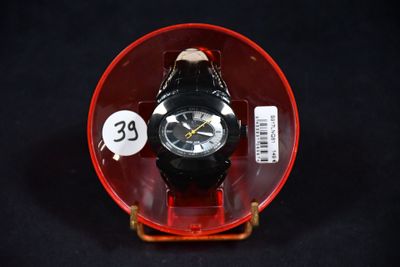 une montre posée dans un récipient rouge sur une surface noire