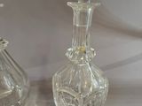two glass vases that are sitting on a table