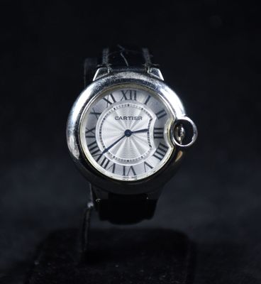 un gros plan d'une montre avec des chiffres romains sur fond noir