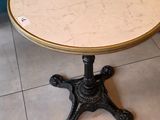 a small table with a marble top on a tile floor