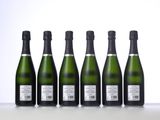 six bottles of sparkling wine lined up in a row