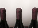three bottles of wine are lined up in a row on a table