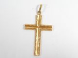 gros plan d'une croix en or sur une surface blanche