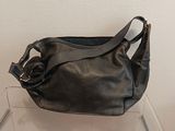 un sac à main noir posé sur une étagère transparente