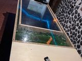 une table avec un plateau en verre sur laquelle se trouve une télécommande