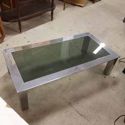 une table en verre avec une base en métal et un plateau en verre